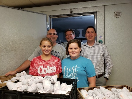 Peoples Bank & Trust employees stand with members of a local 4-H club.