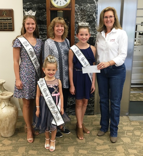 Barbara Price of Peoples Bank and Trust stands with winners of the Greene County Days Pageant.