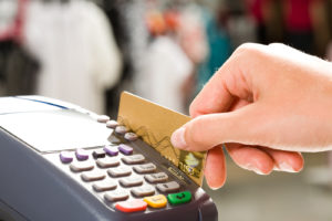 Close-up of human hand holding plastic card in payment machine