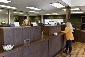 Peoples Bank & Trust teller assisting customer with transaction